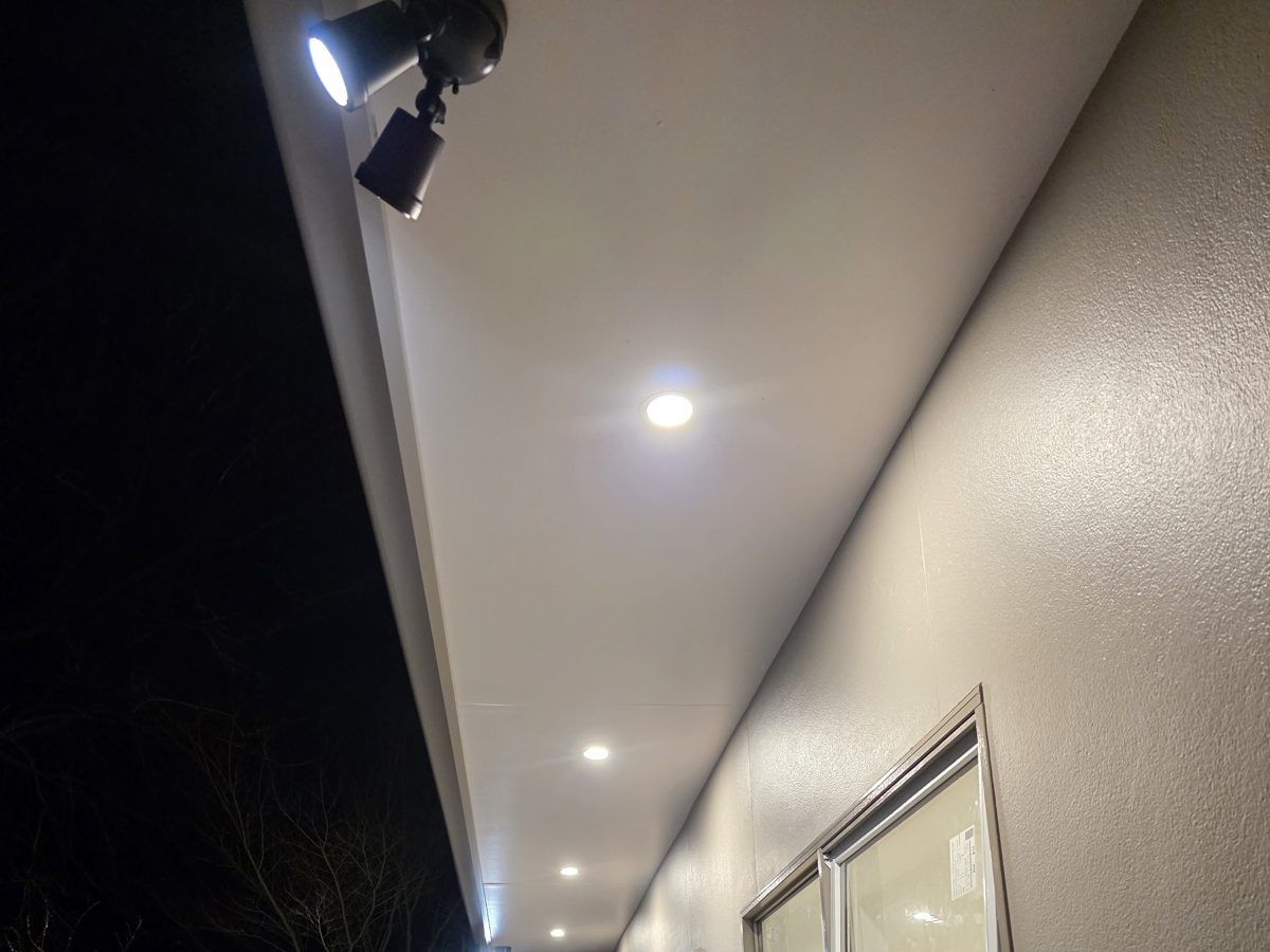 Flood light and downlights under the eaves of a house at night
