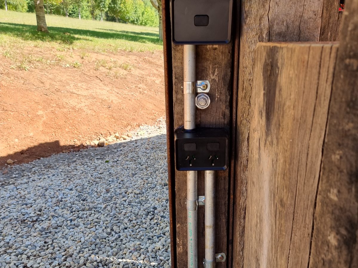 Weatherproof double power point and a black box on a timber post, with metal conduit